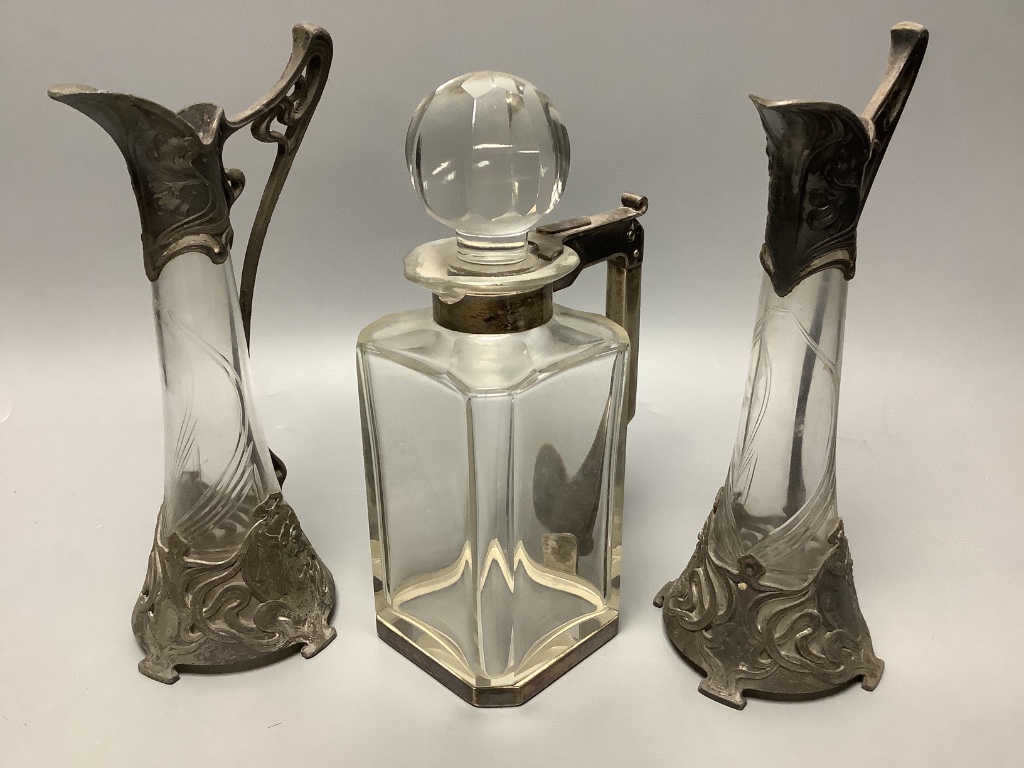 A pair of WMF style pewter-mounted glass jugs and an electroplate mounted spirit decanter, tallest 23cm